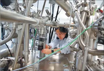  ?? JIN LIWANG / XINHUA ?? A researcher works on catalyst for coal-to-liquids technology at a research institute in Beijing.