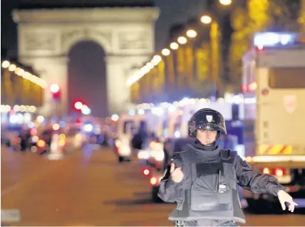  ?? Thibault Camus ?? > A police officer stands guard after a fatal shooting in which a police officer was killed along with an attacker on the Champs Elysees in Paris yesterday. Below, armed police secure the area