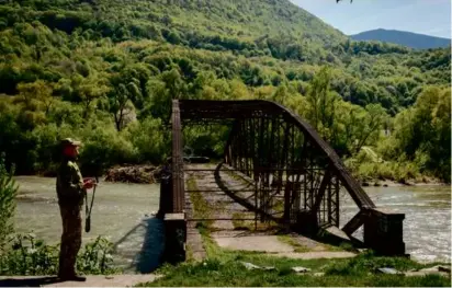  ?? NICOLE TUNG/NEW YORK TIMES ?? A Ukrainian border guard flew a drone over the Tysa River at the Ukraine-Romania border.