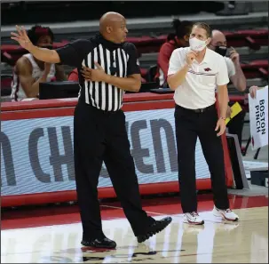  ?? NWA Democrat-Gazette/Andy Shupe ?? WATCHING FROM HOME: Arkansas coach Eric Musselman, right, speaks to a game official during the first half of a Dec. 5 game against Lipscomb in Bud Walton Arena. Musselman did not attend Tuesday’s game against Abilene Christian for contact tracing reasons after a staff member tested positive for COVID-19.