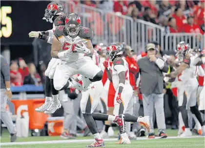  ?? JOHN BAZEMORE/AP ?? Bucs defensive tackle Vita Vea clutches the ball as he celebrates his touchdown catch with linebacker Sam Acho in the win against the Falcons.