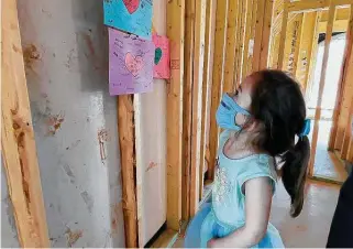  ?? Courtesy of The Howard Hughes Corporatio­n / Submitted ?? Four-year-old Mrazy stops to look at the many notes of love left for her and her dad, Staff Sgt. Stephen Netzley, on April 4. The Bridgeland community wrote letters for the family.