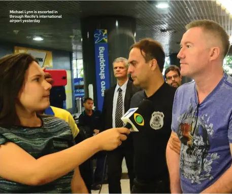  ??  ?? Michael Lynn is escorted in through Recife’s internatio­nal airport yesterday