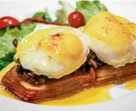  ??  ?? Initially a pub, Blackfish now also serves brunch on Sundays: A Single Pancake (left) is dusted with confection­ers’ sugar and topped with fresh berries, while the gluten-free Benny’s Allergic to Gluten (right) is made with potato rosti and homemade corned beef.