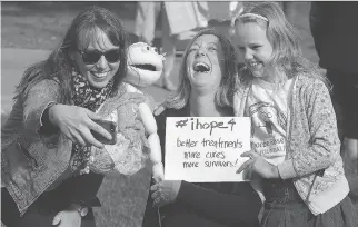  ?? TONY CALDWELL ?? Family, friends and politician­s gathered at Ottawa City Hall with survivors and patients to show their support for all the youths affected by cancer during Childhood Cancer Awareness Day Friday. Marion Doull takes a photo of Sarah Argue and Mae Doull...