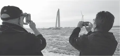  ?? PHOTOS: NICK BRANCACCIO ?? Marc St. Pierre, left, and Kim Cooper stopped Friday to take a few snapshots of a wind turbine that looked to have buckled in the middle of the tower portion on 16th Line near Drake Road, southeast of Merlin, in Chatham-Kent.