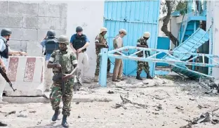  ??  ?? SOLDADOS y personal de rescate se aproximan a la entrada del complejo de la ONU en Mogadisco que fue objeto del atentado.