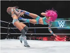 ??  ?? Spektakulä­rer Kick von Sasha Banks (pinkes Haar) gegen Alicia Fox.