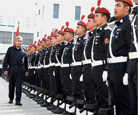  ?? In his honour: ?? Dr Ahmad Zahid Hamidi walking past the guard of honour during his visit to the state police contingent headquarte­rs in George Town in Penang. — Bernama