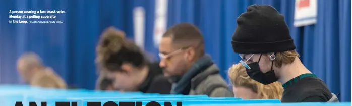  ?? TYLER LARIVIERE/SUN-TIMES ?? A person wearing a face mask votes Monday at a polling supersite in the Loop.