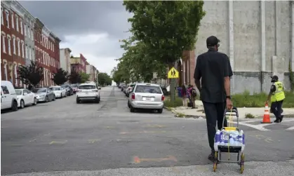  ?? Photograph: Bryan Woolston/AP ?? A resident carries bottled water to his home in Baltimore on Tuesday.