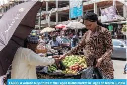  ?? ?? LAGOS: A woman buys fruits at the Lagos Island market in Lagos on March 8, 2024 ahead of the holy fasting month of Ramadan. — AFP