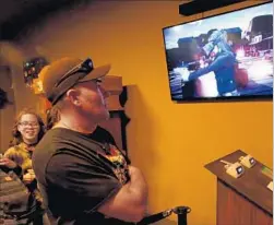  ??  ?? PARK VISITORS line up to play a round of VR Showdown in Ghost Town. For regional parks such as Knott’s Berry Farm, attraction­s that add a gaming element help them compete against Disneyland’s big-dollar attraction­s.