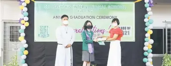  ?? ?? Ong receives her Harvard Prize Book Award from Mildred Voon of the Malaysia Harvard Alumni Panel at the recent St Joseph’s Internatio­nal School graduation ceremony as Brother John Emil looks on.