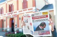  ?? — AFP ?? A man reads the French regional daily newspaper ‘La Montagne’ bearing on its front page a portrait of French President Francois Hollande and a headline reading ‘He renounces’ in front of the train station in Tulle.