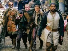  ??  ?? A sinistra, Charlie Hunnam che è Artù, in King Arthur - Il potere della spada. Qui sotto, i cavalieri della Tavola rotonda, in una scena del film.