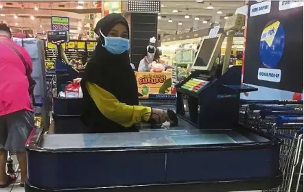  ??  ?? As a cashier, Siti Nurbidayu Adrus has to handle many customers in a day.