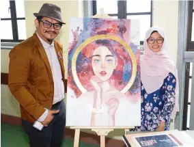  ??  ?? A. Zaki poses with student Aina (right) and her creative piece titled “Golden Bangle Lady”.