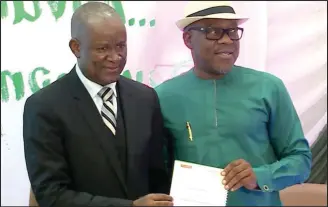  ?? ?? Sports Minister, Senator John Owan Enoh (right) exchanging documents of the MoU signed with MD/CEO of Yanga Games, Mr Derrick David Kentebe in Lagos