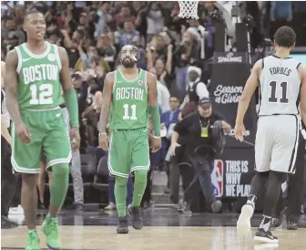  ?? AP PHOTOS ?? TRIPPED UP: Terry Rozier (12) and Kyrie Irving react after the Spurs’ Manu Ginobili (below) hit the deciding 3-pointer in the final seconds, handing the Celtics a tough 105-102 defeat last night in San Antonio.