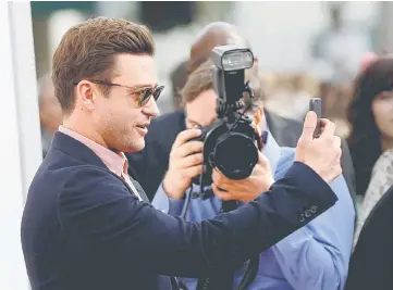 ??  ?? Cast member Timberlake uses his mobile device at the premiere of ‘Trolls’ in Los Angeles, California US, on Sunday. — Reuters file photo