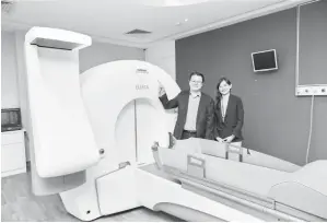  ?? ?? TEKNOLOGI CANGGIH: Seow dan Heng menunjukka­n salah sebuah fasiliti yang digunakan untuk merawat kanser di Pusat Kanser Sunway.