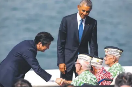  ?? Marco Garcia, The Associated Press ?? Japanese Prime Minister Shinzo Abe, left, and U.S. President Barack Obama visit with Pearl Harbor veterans, seated from left, Sterling Cale, Al Rodrigues and Everett Hyland at Joint Base Pearl Harbor-Hickam in Honolulu on Tuesday.