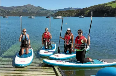  ?? PHOTO: MADDISON NORTHCOTT/ STUFF ?? From left: Reporter Maddison Northcott with Olivia Watkins, Althea Barnes and Rosie Coutts as they try stand-up paddleboar­ding in Akaroa.