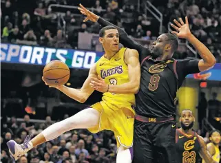  ?? TONY DEJAK/THE ASSOCIATED PRESS ?? Lakers guard Lonzo Ball, left, looks to pass while being defended by Cavaliers guard Dwyane Wade on Thursday in Cleveland. The Cavaliers won 121-112.