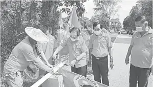  ??  ?? KEMUDAHAN PENDUDUK: Wong (tiga kanan) membantu kerja-kerja pemasangan lampu jalan solar di kawasan Paradom.