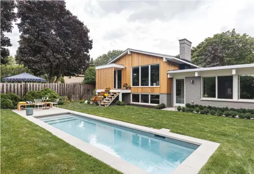  ??  ?? BELOW In the backyard – with grounds by Couture Landscapes and lap pool from Gib-san Pools – one can see how the original gabled portion of the house meshes with the lower, renovated section thanks to impeccable brick and siding.