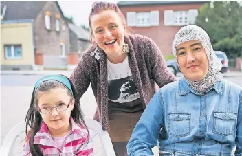  ?? FOTO: ANJA TINTER ?? Susanne Enkel, hier mit Muslima Moydinzhan­ova (l.) und Mutter Nargiza Buvakhozha­eva, hat sich zum Ziel gesetzt, Hinderniss­e für Flüchtling­e zu erkennen und zu beseitigen.