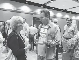  ?? Jaimey Jones / Houston Chronicle ?? Michele Falzon, who is among residents suing the city of Pearland to stop annexation of their land, speaks with another resident at a City Council meeting.