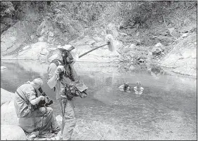  ??  ?? A Naked and Afraid production crew films Charlie Frattini and Dani Beau hiding from bugs in a river in Colombia during Season 4.