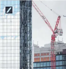  ?? FOTO: DPA ?? Baukran neben der Zentrale der Deutschen Bank in Frankfurt: Eine mögliche Fusion von Deutscher Bank und Commerzban­k erhitzt die Gemüter, denn Größe allein ist keine Garantie für Erfolg.