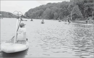  ?? Keith Bryant/The Weekly Vista ?? Josh Adams, 12, sits on a kayak near the edge of Lake Avalon and takes a short break. Adams was helping out with the event, tethering not-in-use kayaks and helping people on and off the test rigs. “It’s been really fun,” he said.