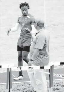  ?? Submitted Photo ?? Forrest City High School Senior Chancellor Taylor talks with FCHS Track Coach Donnie Willis during a track meet.