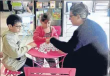  ??  ?? Maman et enfants participen­t à l’atelier découverte de jeux de siciété Oika Oika, animé par Hélène (pht Steph)