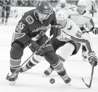  ?? RIC ERNSTZ, THE CANADIAN PRESS ?? Canucks defenceman Alex Biega battles for the puck with Capitals forward Jay Beagle during the second period in Vancouver on Thursday.