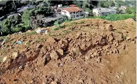  ??  ?? Looming some distance over Bandarawel­a town:
A garbage mountain reminiscen­t of Colombo’s Meethotamu­lla