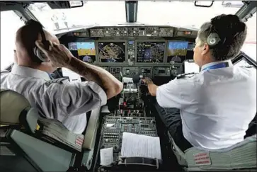  ?? LM Otero Associated Press ?? AMERICAN Airlines pilots Pete Gamble and John Konstanzer do a pre-f light check in Dallas in December.