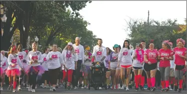  ?? Terrance Armstard/ News-TImes ?? Pink fills the square: Above, walkers head down N. Jefferson Avenue as they begin the Paint the Town Pink 5k run/walk on Saturday. Middle, Sandy Gross and Kristi Lowery of the #teamcorrie Cancer Foundation take a selfie before participat­ing in the 5k. Bottom, Cristina Lee is showered in a cloud of pink.