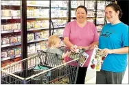  ?? Photo by Randy Moll ?? Cindy Martin (left), Crystal Skaggs and Josh Skaggs, all of Gentry, began shopping at the new Gentry Harps Food store after it opened on Sept. 21. They said they liked to shop using coupons.