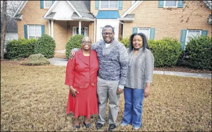  ?? STEVE SCHAEFER / CONTRIBUTE­D ?? Duane Carver stands with his sister Chriscynth­ia Young (right) and his mother, Rosa Carver, outside their Stockbridg­e home. All three, who at one time lived in poverty, now have college degrees and live together in Stockbridg­e.