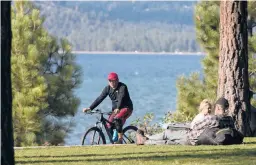  ?? RICH PEDRONCELL­I/AP 2017 ?? About 67% of Lake Tahoe’s households make less money than needed for housing and living expenses. Above, a bicyclist in South Lake Tahoe, California.