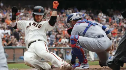  ??  ?? San Francisco Giants’ Brandon Crawford (35) slides safe at home against Los Angeles Dodgers catcher Yasmani Grandal (9) during the second inning of a baseball game in San Francisco, on Saturday. AP PHOTO/JIM GENSHEIMER