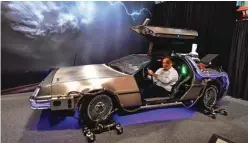  ?? ?? Propstore vice-president of business developmen­t and marketing Chuck Costas sits in a lit-up full size DeLorean Time machine replica vehicle used for Universal Studios promotiona­l events from the 1985-1990 “Back to the Future” trilogy of films at Propstore.