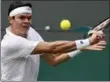  ?? KIRSTY WIGGLESWOR­TH, THE ASSOCIATED PRESS ?? Milos Raonic returns to Jan-Lennard Struff in their match at Wimbledon. Raonic won, 7-6 (5), 6-4, 7-6 (4).