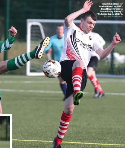  ??  ?? Kevin Bull clears for Newfoundwe­ll as OMP’s David Bowens tries to block during Sunday’s FAI Junior Cup tie at DIFE.