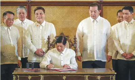  ?? KJ ROSALES/PPA POOL ?? PRESIDENT Ferdinand R. Marcos, Jr. signs into law the Tatak Pinoy Act and the Expanded Centenaria­ns Act at the Ceremonial Hall of the Malacañan Palace on Feb. 26.